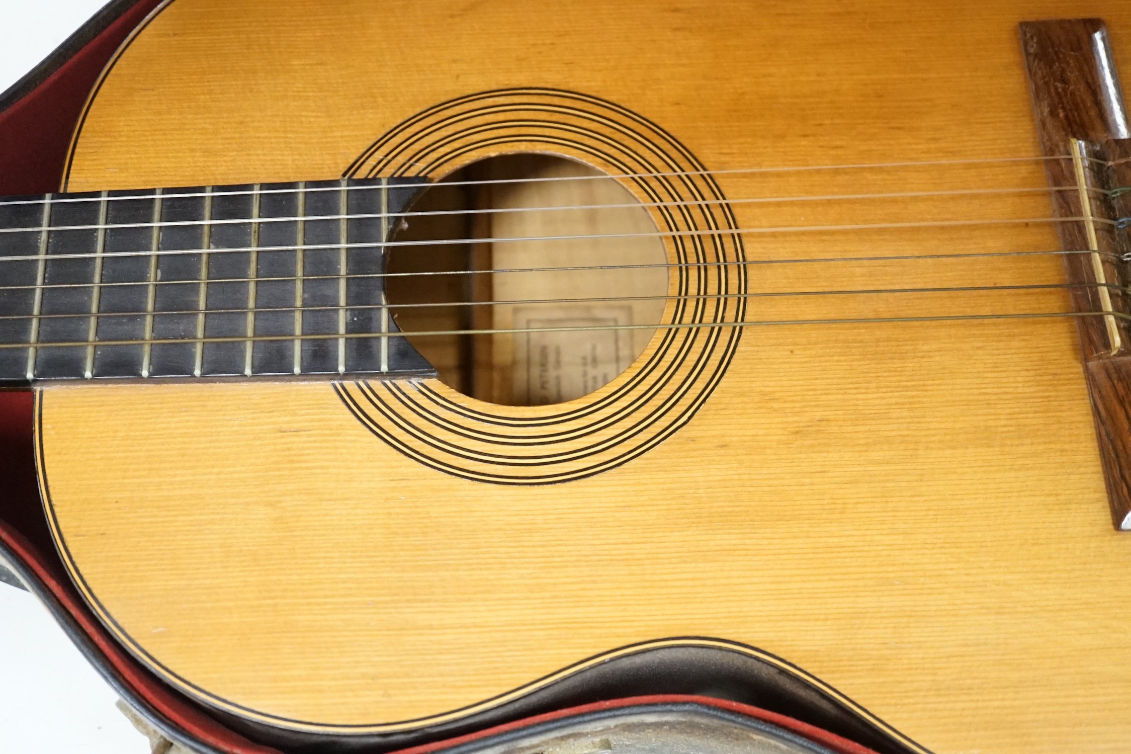 A Harald Petersen classical concert guitar, paper label interior, with hard case. Length of back 49cm excluding button
